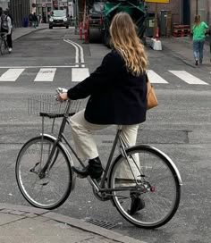 a woman is riding her bike down the street