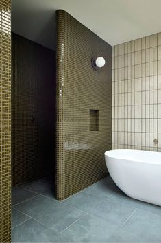 a bathroom with a large white bathtub next to a walk in shower and tiled walls