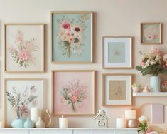 a white mantle topped with lots of framed pictures and vases filled with pink flowers