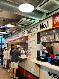 people are lined up in line to order food at the tacos restaurant, which is open for business