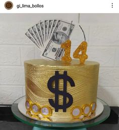 a gold cake with a dollar sign on top and some money sticking out of it