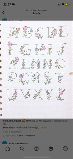 an open notebook with flowers and letters on it