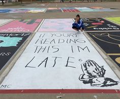 a woman kneeling on the ground in front of some chalk drawings that read if your reading this i'm late