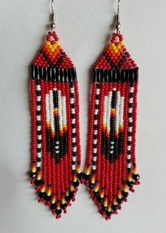 red, black and white beaded earrings hanging from hooks