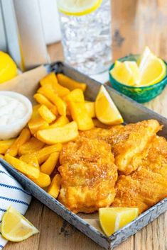 fish and chips with lemon wedges on the side