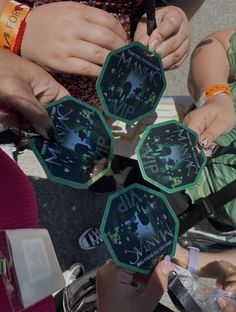 four people are holding up small clocks with numbers on them and hands pointing to the same time