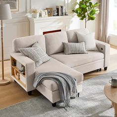 a living room with a couch, coffee table and rug on the floor in front of a fireplace