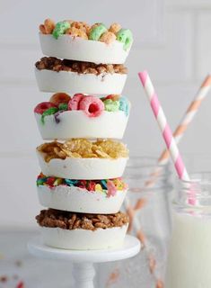 four desserts stacked on top of each other with milk and strawberries in the background