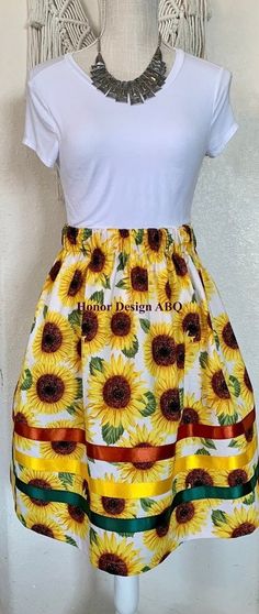 Traditional ribbon skirt in sunflower floral floral print.  Finished with elevated details such as yellow, green and rust satin ribbon, lovingly made by hand. A paper bag waist hugs the body, while also being comfortable to wear. See our sizing details below to find your perfect size.  Ready to ship! A long time symbol femininity, sisterhood and solidarity, used in ceremony and everyday, every skirt tells a story written by the woman who wears it. Perfect for every season, dressed up or down. Sa Sunflower Ribbon Skirt, Time Symbol, Paper Bag Design, Ribbon Skirt, Ribbon Skirts, A Line Cut, Sunflower Print, Satin Ribbon, Paper Bag