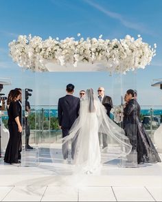 a bride and groom walking down the aisle at their wedding ceremony on top of a building