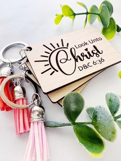 a keychain with the words look into christ on it and tassels