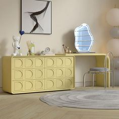 a room with a yellow dresser, chair and mirror on the wall next to it