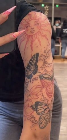 a woman's arm with butterflies on it and a cell phone in her hand