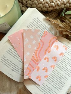 three books sitting on top of a wooden table next to a candle