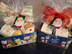 two tins filled with christmas treats sitting on top of a counter