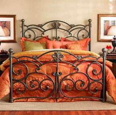 a bed with an orange comforter and pillows