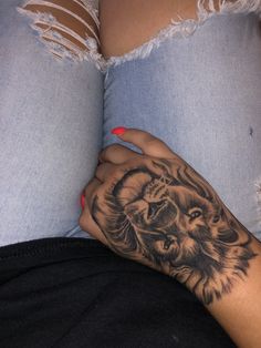 a woman's hand with a lion tattoo on her left arm and the bottom half of her stomach