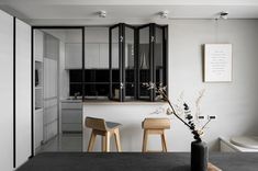 a black and white kitchen with three stools in front of the counter top area