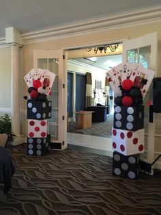 two tall black and white polka dot columns with cards on them in front of a door