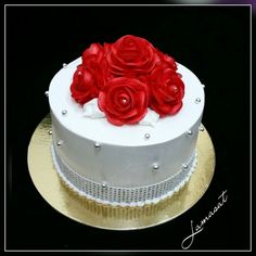 there is a white cake with red roses on it