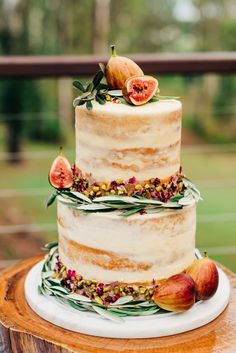 a three tiered cake with figs on top