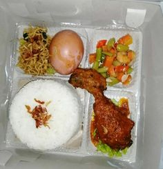 a plastic container filled with rice, meat and veggies next to an egg