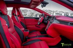 the interior of a sports car with red leather and black trims, overlooking a cityscape