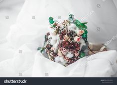 a bouquet of flowers is wrapped in white tissue paper and placed on top of the bed