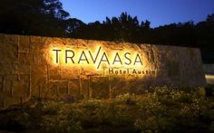 the sign for travaasaa hotel and suites lit up at night with lights