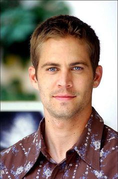 a close up of a person wearing a shirt and looking at the camera with a serious look on his face