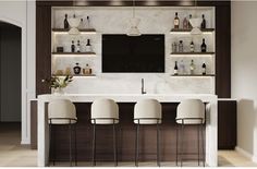 a bar with four stools in front of it and a television mounted on the wall