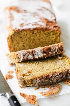 two slices of banana bread sitting on top of a piece of paper next to a knife