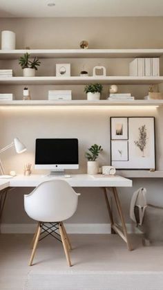 a home office with white furniture and shelves on the wall, along with a computer