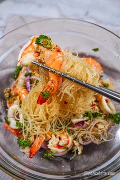 a glass bowl filled with noodles and shrimp