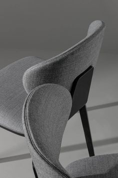 an upholstered chair with curved backrests is shown in black and white