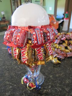 an assortment of candy wrapped in foil and sitting on a counter top next to other candies