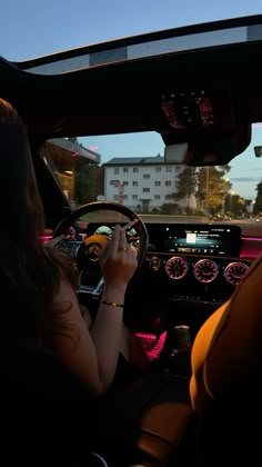 a woman driving a car at night with her hands on the steering wheel