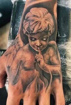 a person's hand with a tattoo on it and an angel holding a pipe