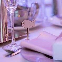 a close up of a table setting with wine glasses and silverware on the table