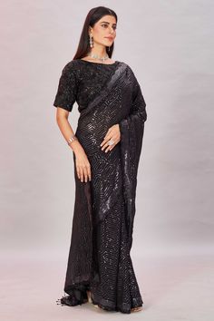 Go for a modern saree look on special occasions in this classy black sequin georgette saree. The saree comes with an embroidered designer blouse. Black Pre-draped Saree With Sequins, Glamorous Black Fitted Pre-draped Saree, Elegant Black Pre-draped Saree With Mirror Work, Designer Wear Pre-draped Georgette Saree With Sequins, Black Georgette Pre-draped Saree With Resham Embroidery, Black Pre-draped Saree With Resham Embroidery, Evening Georgette Sequin Fabric With Traditional Drape, Festive Black Pre-draped Saree With Self Design, Embellished Black Pre-draped Saree For Party