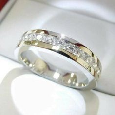 a gold and white diamond ring sitting on top of a table