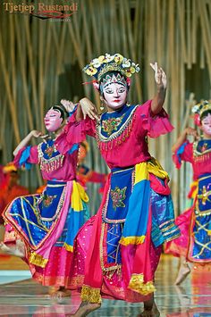 dancers in colorful costumes are performing on stage