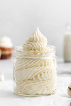 a jar filled with whipped cream next to some cookies