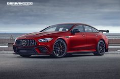 a red mercedes amg coupe parked in front of the ocean