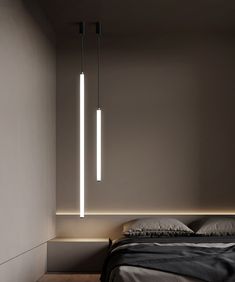 a bed with two lights hanging from it's sides in a room next to a wall