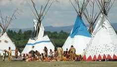 several teepees with people standing around them