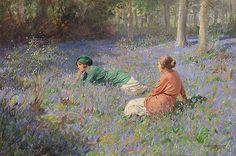 two women in a field of bluebells, one laying down and the other standing up