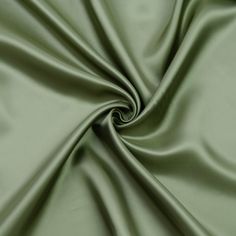 a close up shot of a plain green fabric with very soft folds and smooth lines