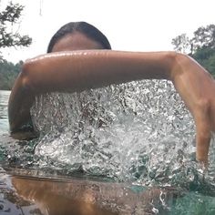 a woman is swimming in the water with her arm outstretched