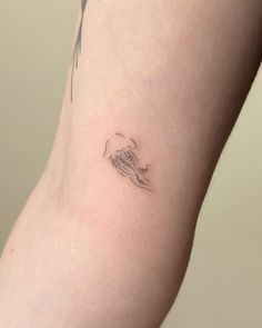 a woman's arm with a small tattoo on the left side of her body